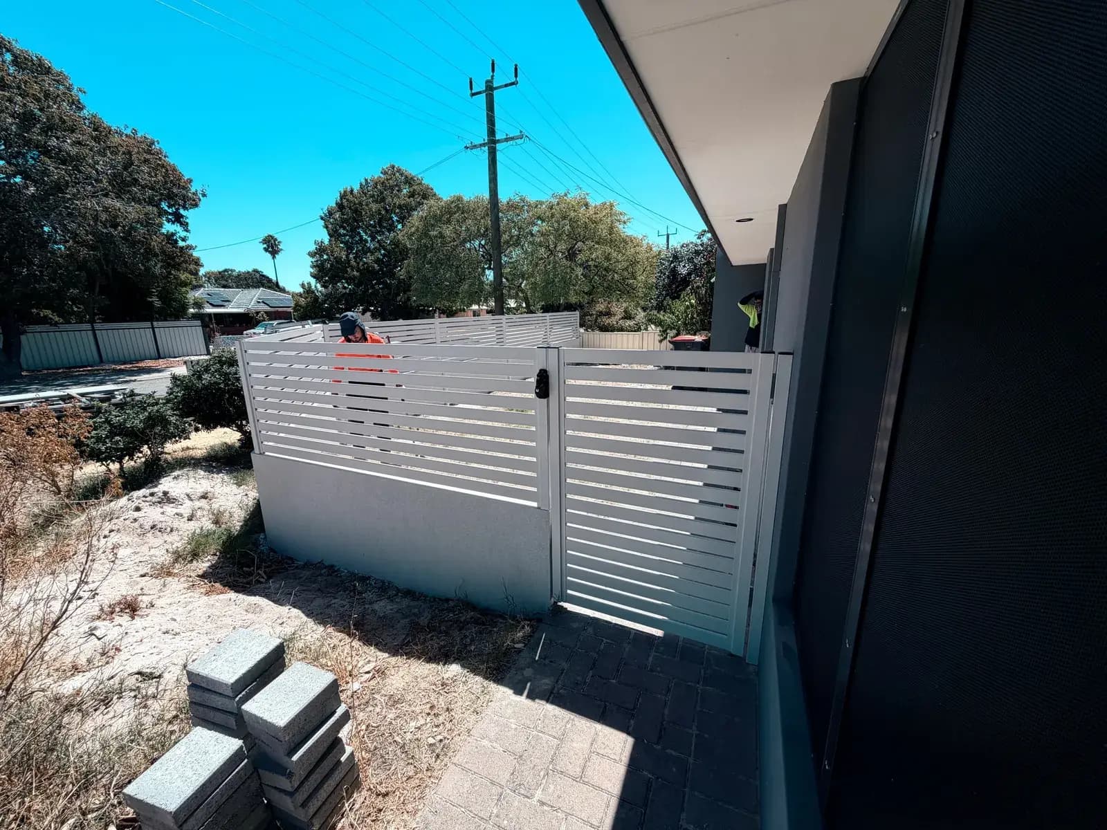 A white slat fence and gate installed by our team